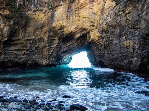 口を開ける龍宮窟、エメラルドグリーンの海が映える洞窟