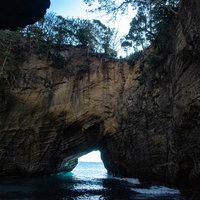 龍宮窟の洞窟内から水面に差し込む光と海岸景観の写真