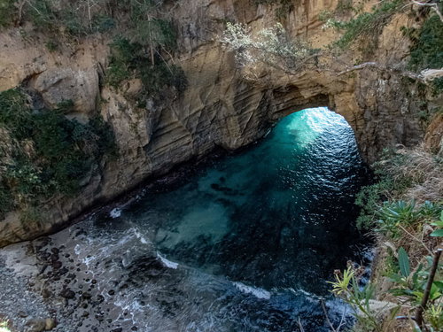 口を開ける海食洞・龍宮窟の波打ち際と洞窟内部