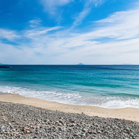 下田市の浜辺に打ち寄せる波と白い砂浜、龍宮窟の海岸風景の写真