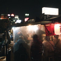 満席の福岡屋台のラーメン店で営業する夜間の風景の写真