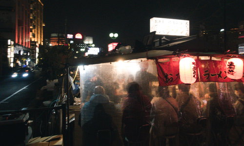 満席の福岡屋台のラーメン店で営業する夜間の風景