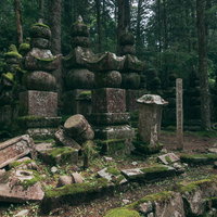高野山金剛峯寺境内の崩れ落ちた古い墓石と歴史的な石積み遺構の写真