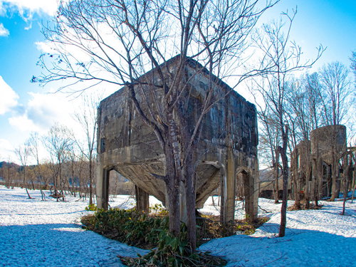 残雪が積もるコンクリート製ホッパーの廃工場