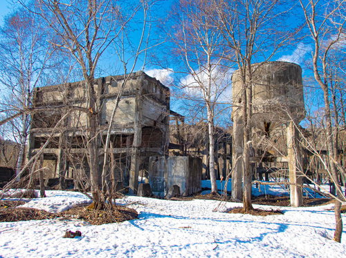 雪化粧した廃工場の遺構とホッパー跡