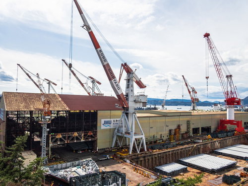 呉市の造船所で稼働する大型クレーン群と建造中船舶