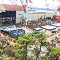 呉の造船所でクレーンが稼働する大規模工業地帯の船舶建造風景の写真