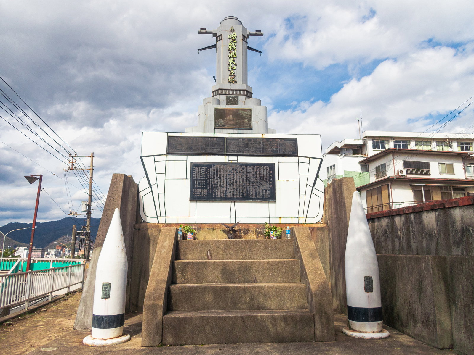 戦艦大和之塔の記念碑。白いコンクリート製の塔身に刻銘板が設置され、手前に階段がある