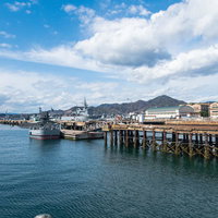 呉の港に停泊する自衛隊の軍艦と木製桟橋の写真