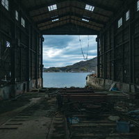 廃墟化した造船工場の船台から望む海と山並みの写真