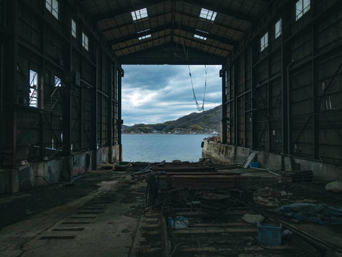 廃墟化した造船工場の船台から望む海と山並み