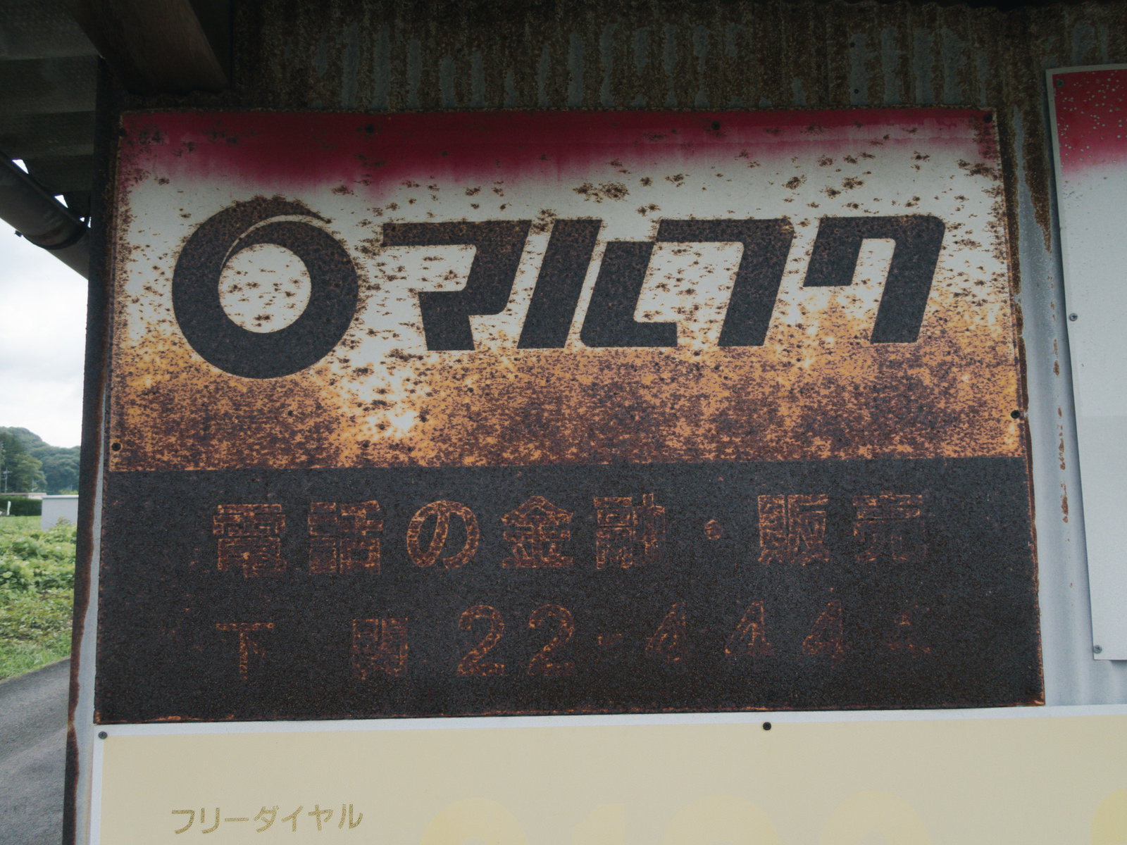 全体的に錆で茶色く変色したマルフクの看板