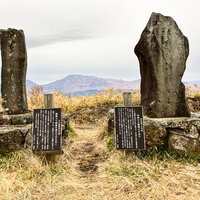 大観峰に立つ句碑と阿蘇の山並みの写真