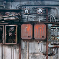 ボロボロに錆びた廃工場の電気系統遮断機と配電盤の写真