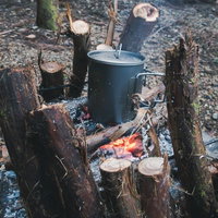 焚火の炎で調理するキャンプ料理と薪火での野外炊事の写真