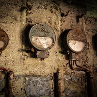 製紙工場のボロボロに錆びた電流計と産業用メーター群の写真