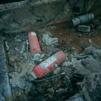 不法投棄された瓦礫と赤い消火器が散乱する汚染現場の写真