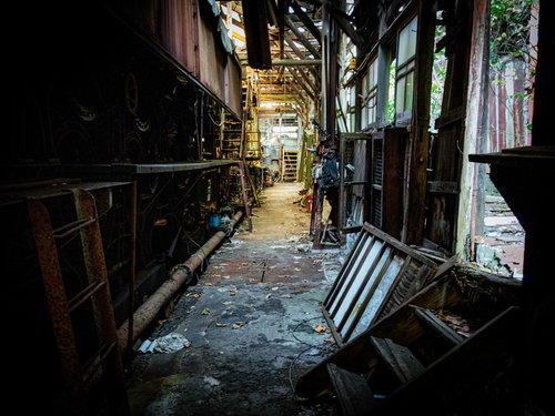 廃墟と化した製紙工場の薄暗い通路と朽ちた設備