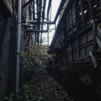 製紙工場の裏側にある薄暗い抜け道の写真