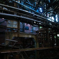 崩れ落ちた製紙工場の内部・老朽化した機械と配管の写真