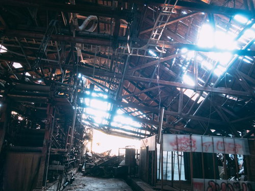 廃工場で崩れ落ちた天井から差し込む光と錆びた骨組み