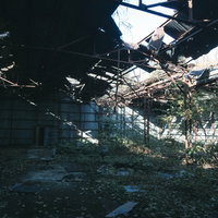 崩れ落ちた屋根と置き去りの椅子 廃工場の天井崩壊の写真