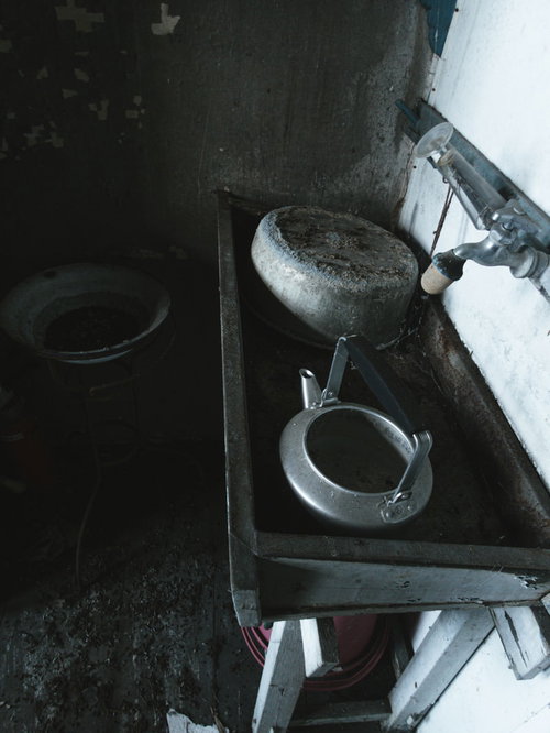 廃病院の錆びた不気味な流し台に置かれた古いやかんと散乱物