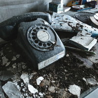 瓦礫に埋もれた埃を被った黒電話、古い廃墟の写真