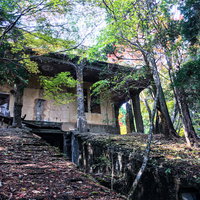 森の中に残るケーブルカー駅舎跡と木々に囲まれた廃墟の写真