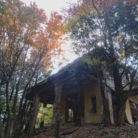 紅葉に囲まれたケーブルカー駅舎跡の倒壊した建物の写真