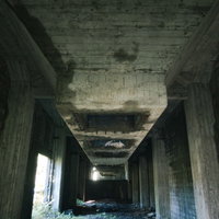 劣化したコンクリート造りの炭鉱貯炭場跡のホッパーと建造物の写真