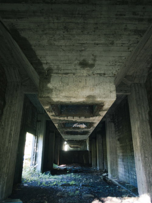 劣化したコンクリート造りの炭鉱貯炭場跡のホッパーと建造物