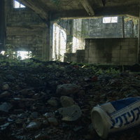 炭鉱遺構のコンクリート建物内に転がる空き缶の写真