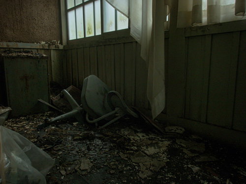 朽ちた部屋に倒れたボロボロのオフィスチェア