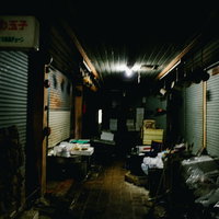 閉ざされたシャッターの前に積まれたゴミ山の写真