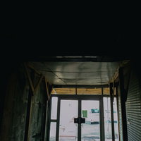 薄暗いアーケード内から光が見える廃墟のような市場の出口の写真