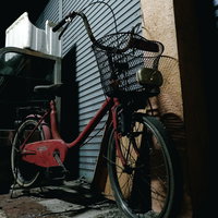 神野市場のシャッター街に停められた赤い自転車の写真