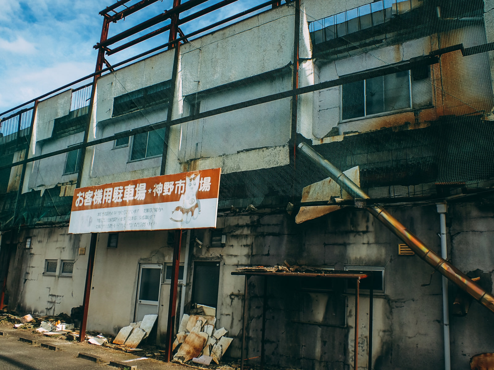 神野市場のシャッター街でコンクリート造りの建物とオレンジ色の看板