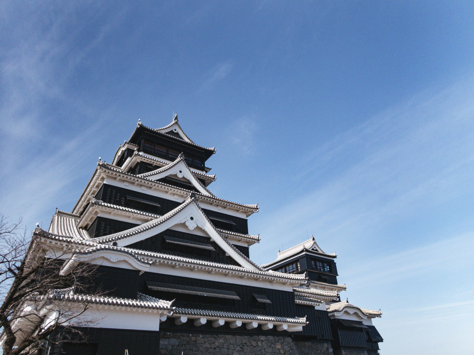 石垣の上に建つ熊本城の天守閣と青空