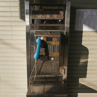 台湾の駅前に設置された古い公衆電話ボックスの写真