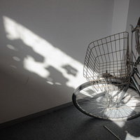 室内に置かれた自転車と窓からの陽光が作る影の写真