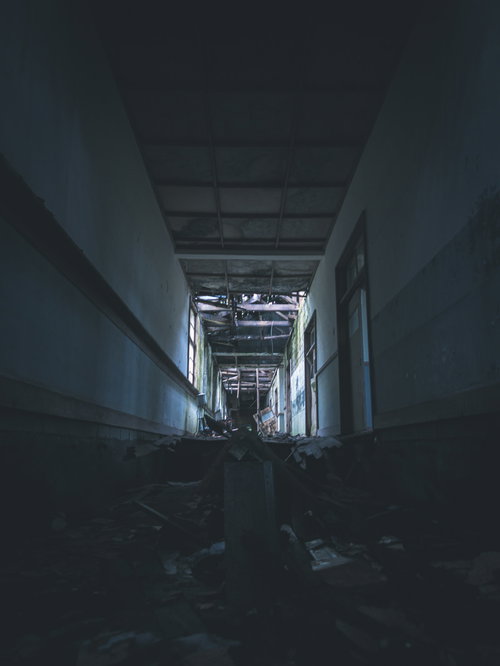 天井が崩落した廃墟の薄暗い廊下