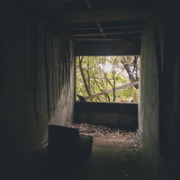 廃墟の窓辺に置かれた椅子の写真