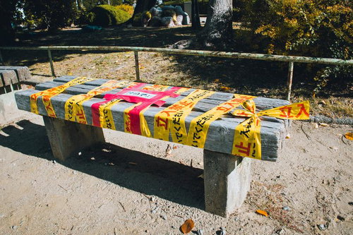 立入禁止テープが巻かれたベンチ