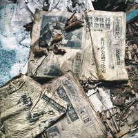 地面に散乱する不法投棄された新聞紙とゴミの写真