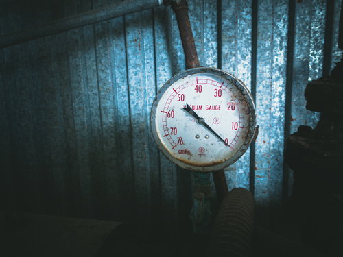 動かなくなった錆びた古い計器の針と目盛り