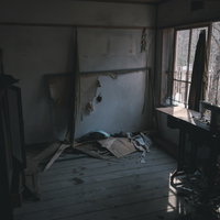 廃屋に取り残された古いミシンと荒廃した室内の写真