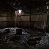 換気口の痕跡から差し込む光と散乱する瓦礫の写真