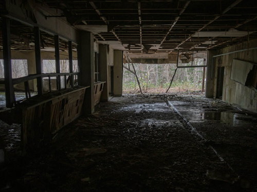 崩れ落ちた天井と床に溜まった暗がりの水溜り