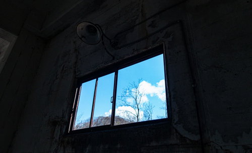 廃墟の窓から見える青空と雲、時間経過による荒廃の痕跡